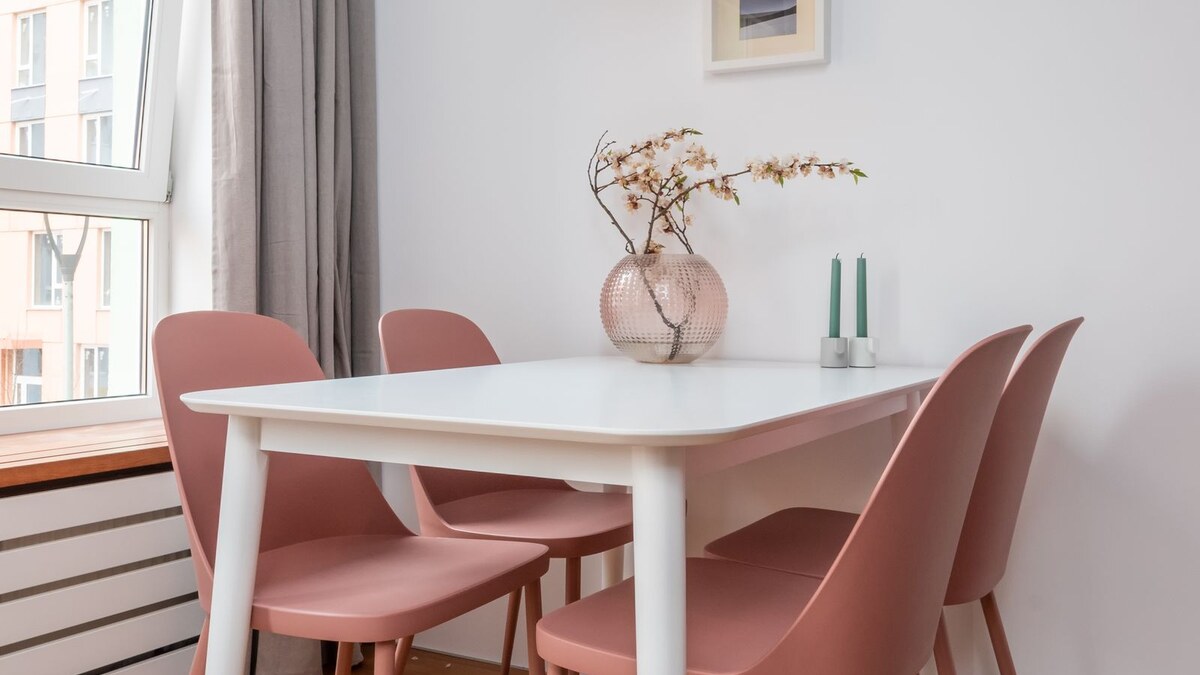Padded folding dining chairs beside a small drop-leaf table in a bright apartment