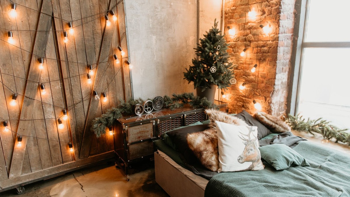 Warm LED strip lighting glowing behind a floating shelf in a small apartment at night