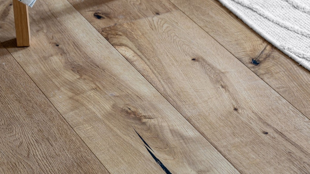 Wood-look peel-and-stick vinyl plank flooring being laid over an old rental floor